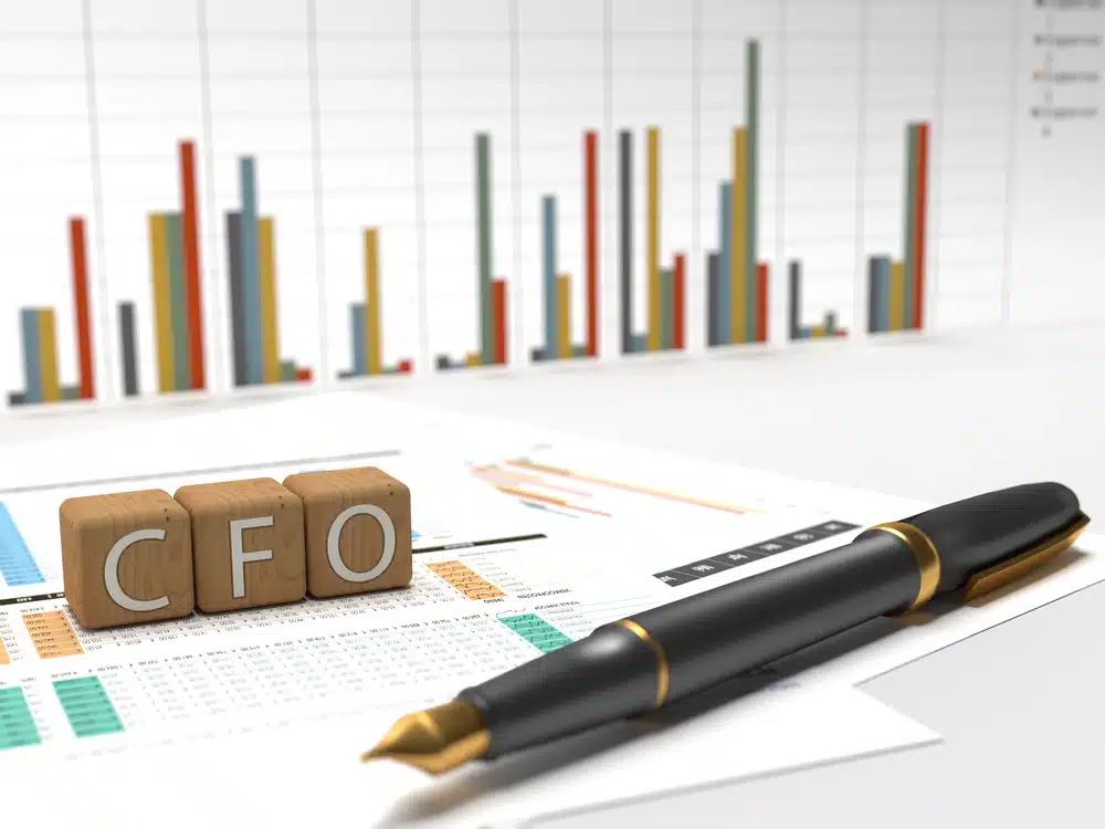 The word CFO on top of a pen and graphs, featuring Carlos Navarro as the Chief Finance Officer.