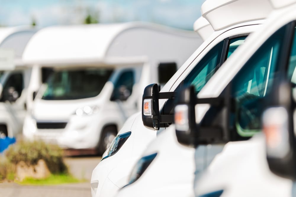 An average row of white rvs parked next to each other.