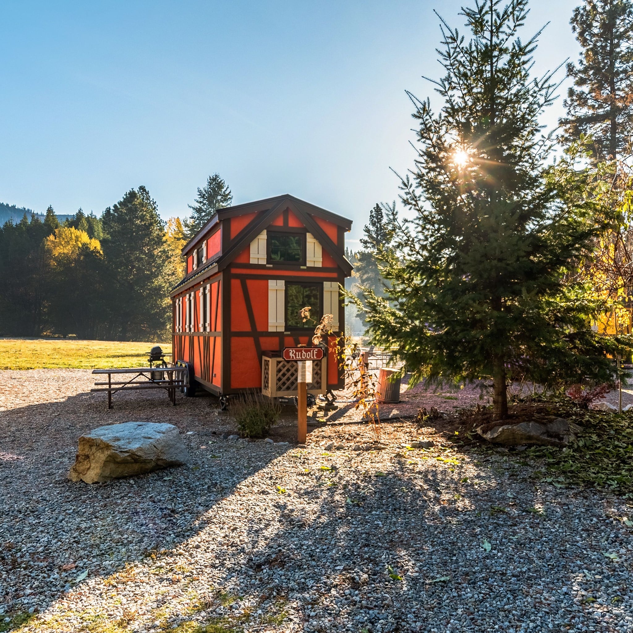 A Petite Retreats tiny house sits on the side of a gravel road, offering the perfect glamping vacation for those looking to win at experiencing simplicity and comfort in nature.