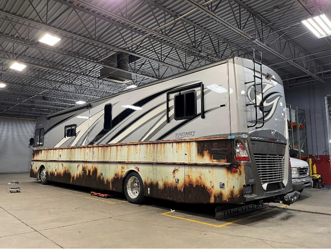 A family RV is sitting in a garage.