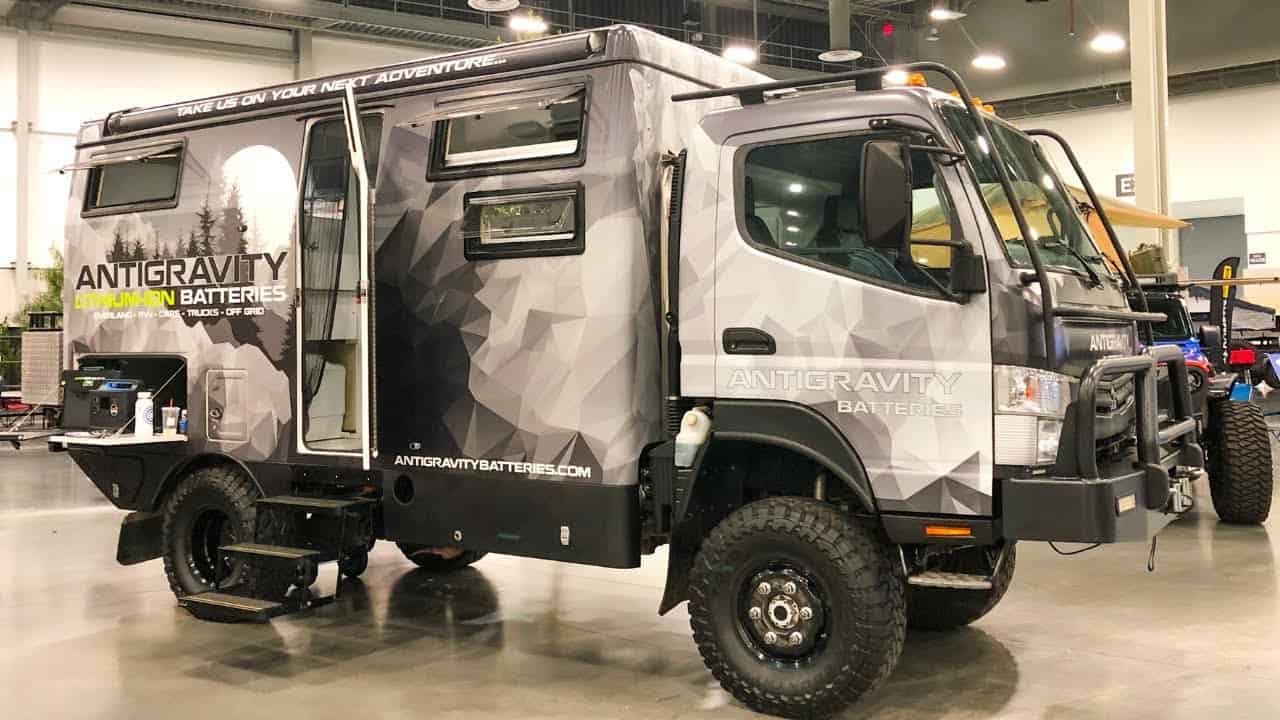 An EarthCruiser, a black and white truck, is parked in a showroom.