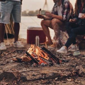A group of people in the Queenstown Lakes District Council area, practicing freedom camping around a campfire.