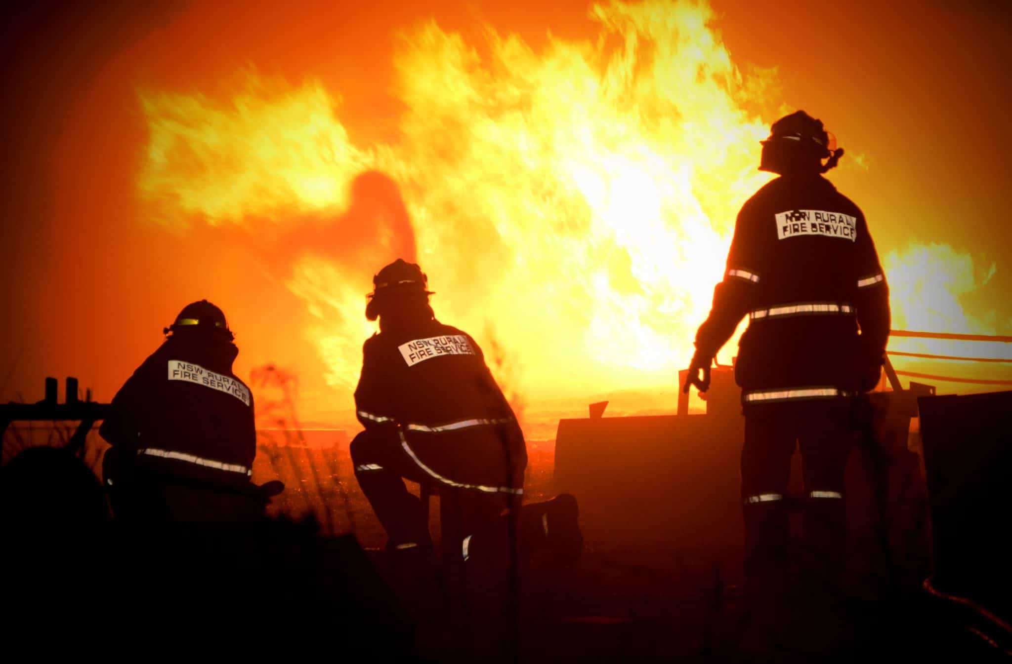 Three firefighters bravely battle a dangerous bushfire at a campground.