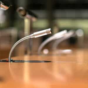 Microphones on a wooden table in a conference room at Board.