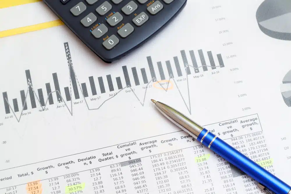 A Rev Group pen and a calculator on top of a fiscal 2022 sheet of paper.