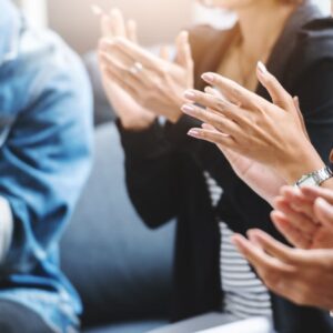 A group of people clapping together at the National Campground Association.