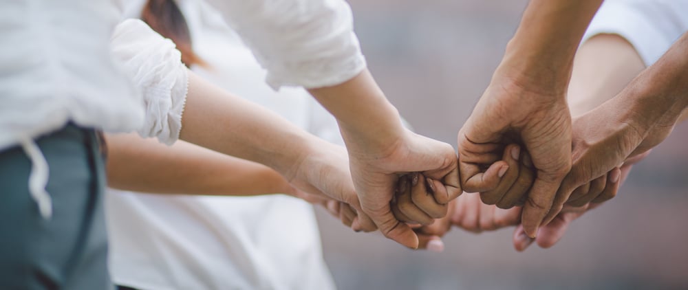 A group of people holding hands together.