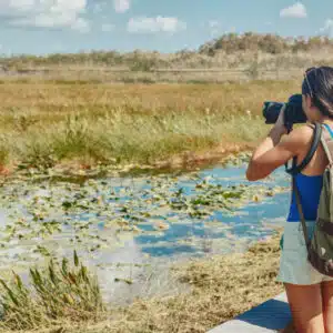 A woman is capturing the beautiful marshland scenery, promoting wildlife conservation and encouraging recreation opportunities.