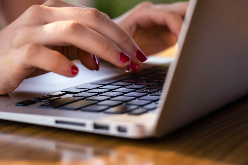 A woman experiencing the momentum of growth while typing on a Campspot laptop keyboard.