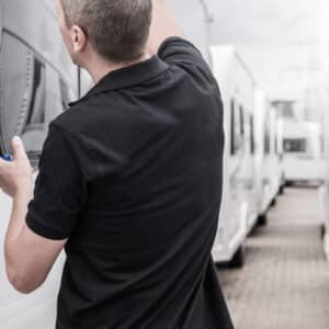 A man is repairing a window on an rv.