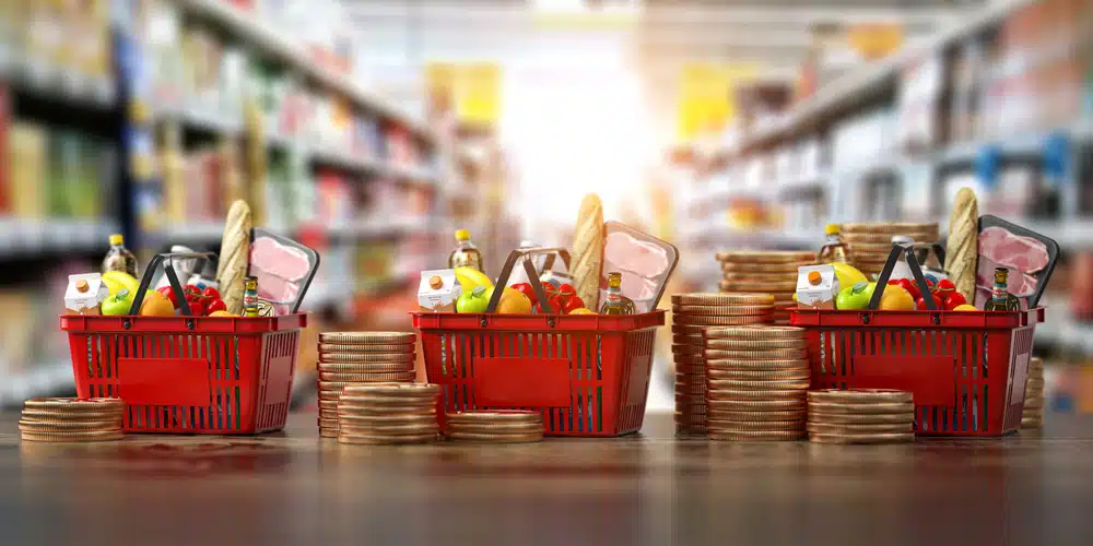 Wholesale shopping baskets full of food and coins in a supermarket.