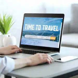 A woman using a laptop with the word time to travel on it, showcasing growth in the Q3 Pitchup.