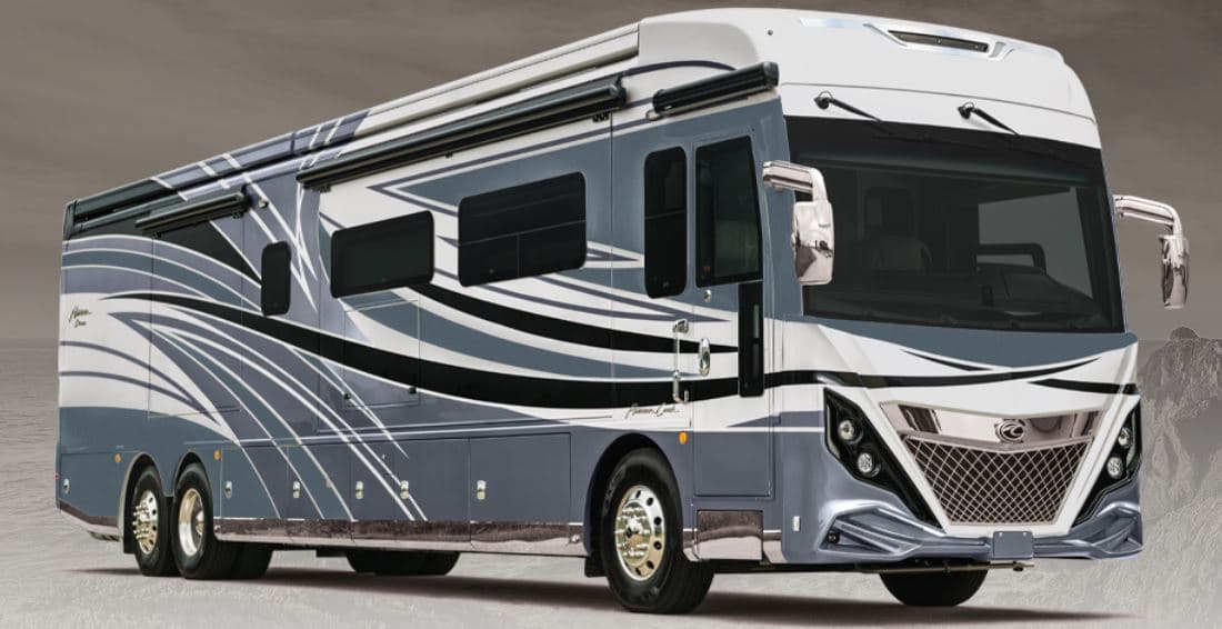 The REV Recreation Group accelerates innovation with their gray and white RV parked in a field.