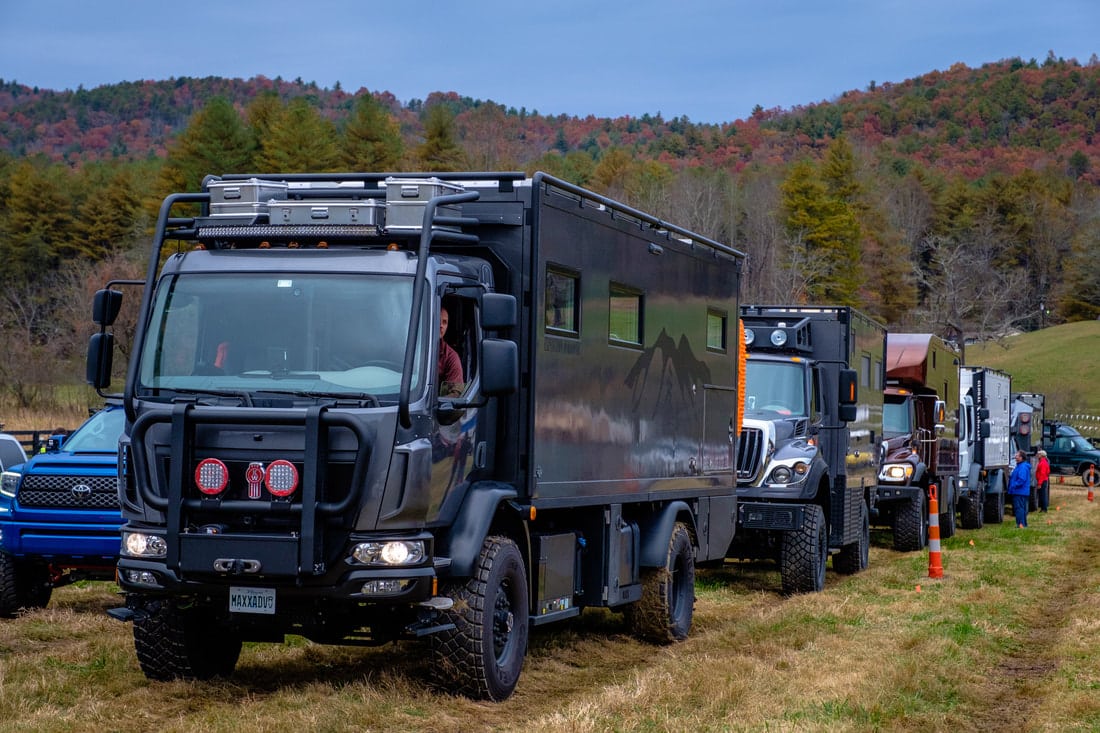 An acquisition of Global Expedition Vehicles and Storyteller Overland resulted in a group of trucks parked in a field.