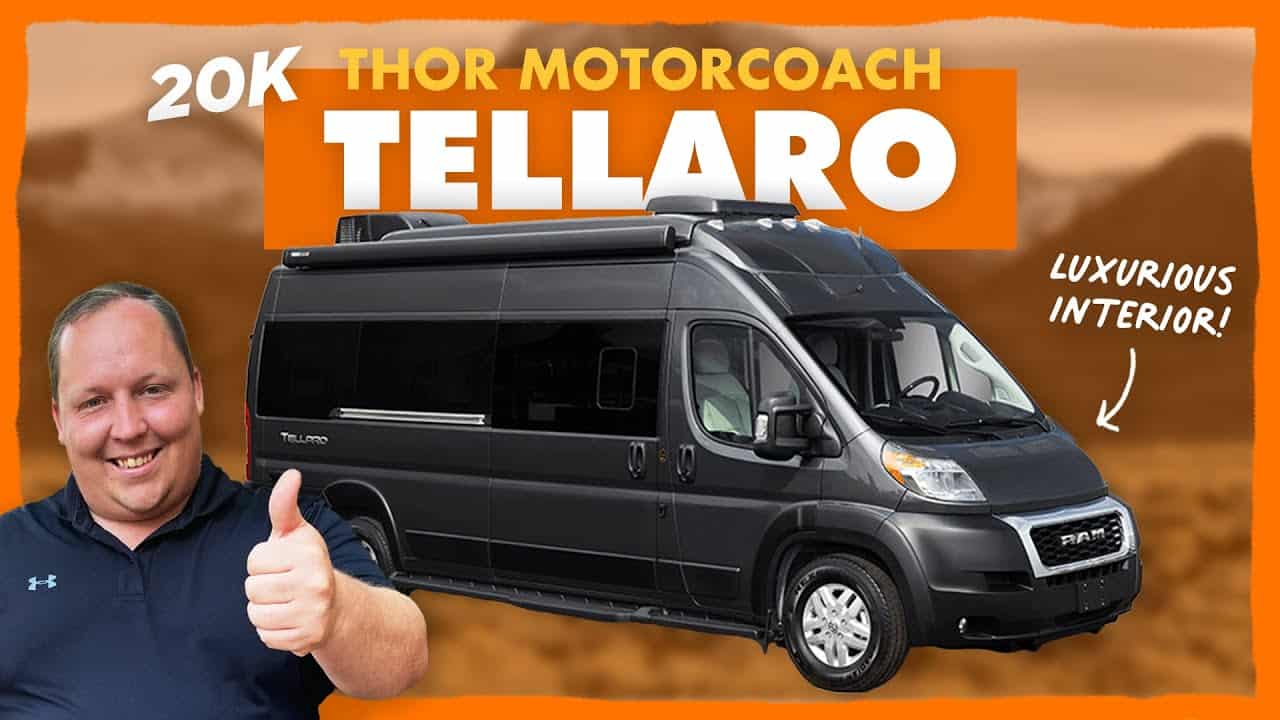 The smallest solo traveler is giving a thumbs up in front of a black Class B motorhome.