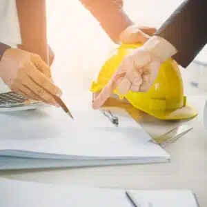 Two people working on a project with a hard hat on their heads.