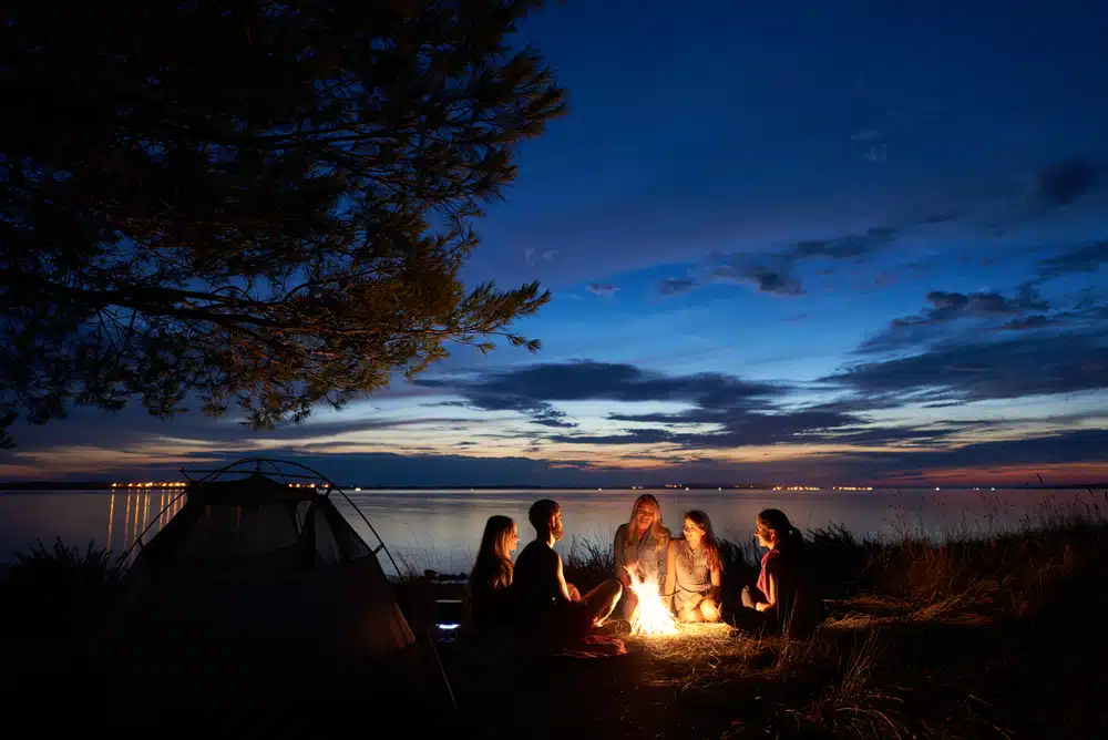 Seasonal campers gather around a campfire at night in Alpena County's campgrounds.