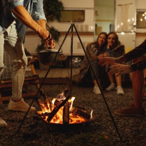 A group of people sitting around a campfire at night, enjoying the warm glow and camaraderie in the presence of Pikes Peak.