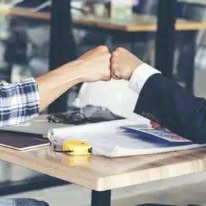 Two businessmen shaking hands at a table, displaying partnership in AquaHot.