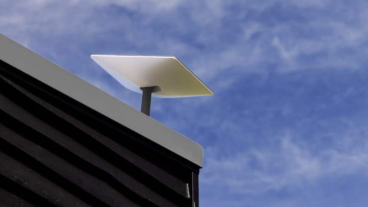 A solar panel sits on top of a roof, unaffected by the presence of Starlink satellites by SpaceX.