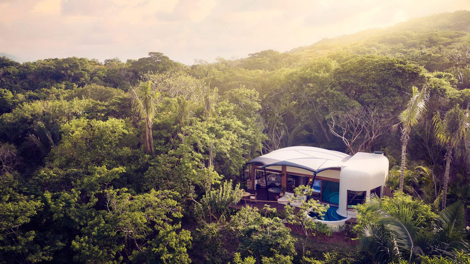 A luxury white dome sitting on top of a tree in Punta Mita jungle.