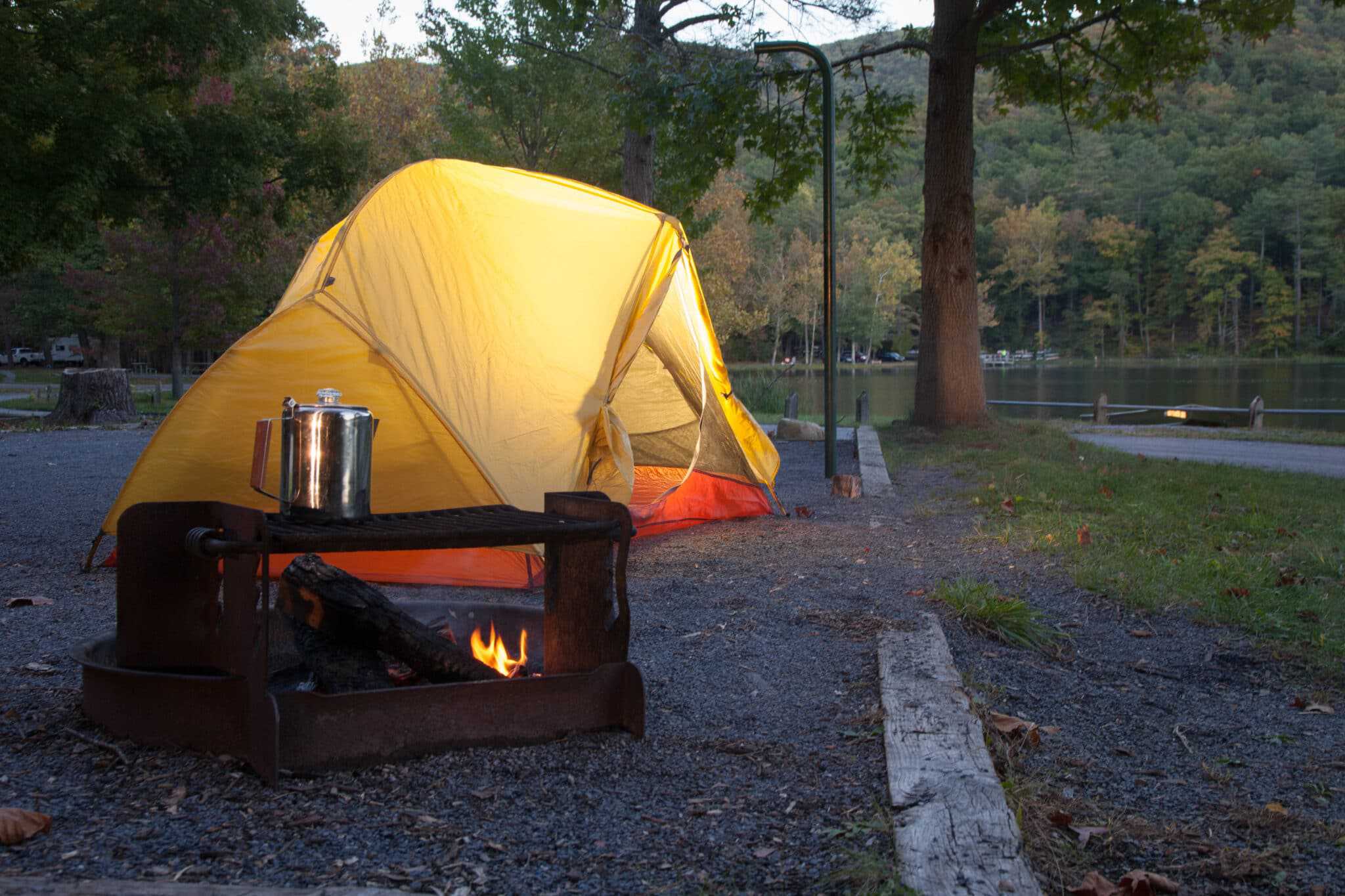 Ein gelbes Zelt neben einer Feuerstelle in den Virginia State Parks.