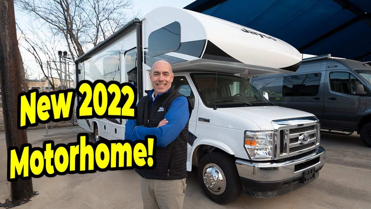 A man standing in front of a new 2022 Jayco Greyhawk 27U motorhome.