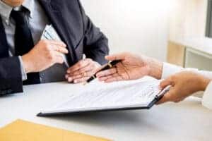 Two people signing a document at a desk in a tourist accommodation establishment in Teesdale, amidst the visitor surge.