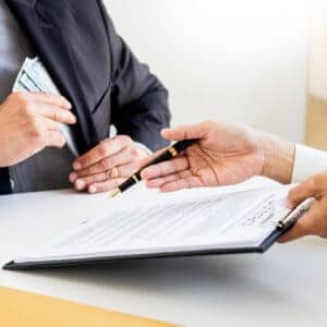 Two people signing a document at a desk in a tourist accommodation establishment in Teesdale, amidst the visitor surge.