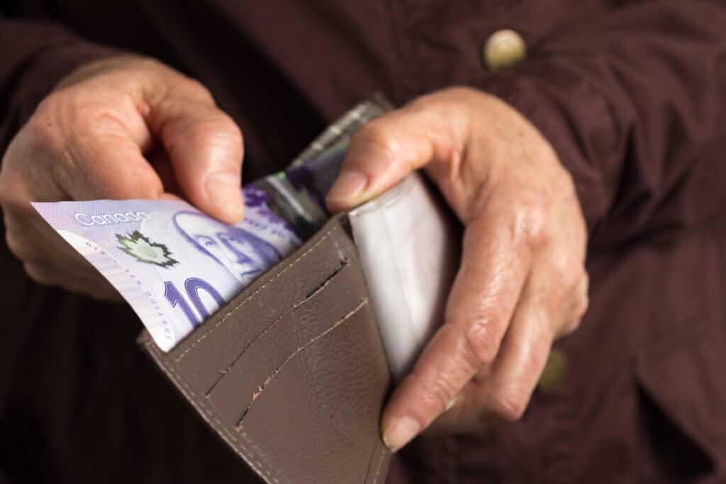 A woman is holding a wallet with money in it.