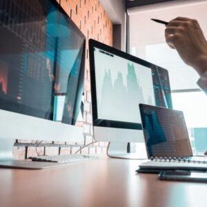 A man is working at a desk with two monitors.