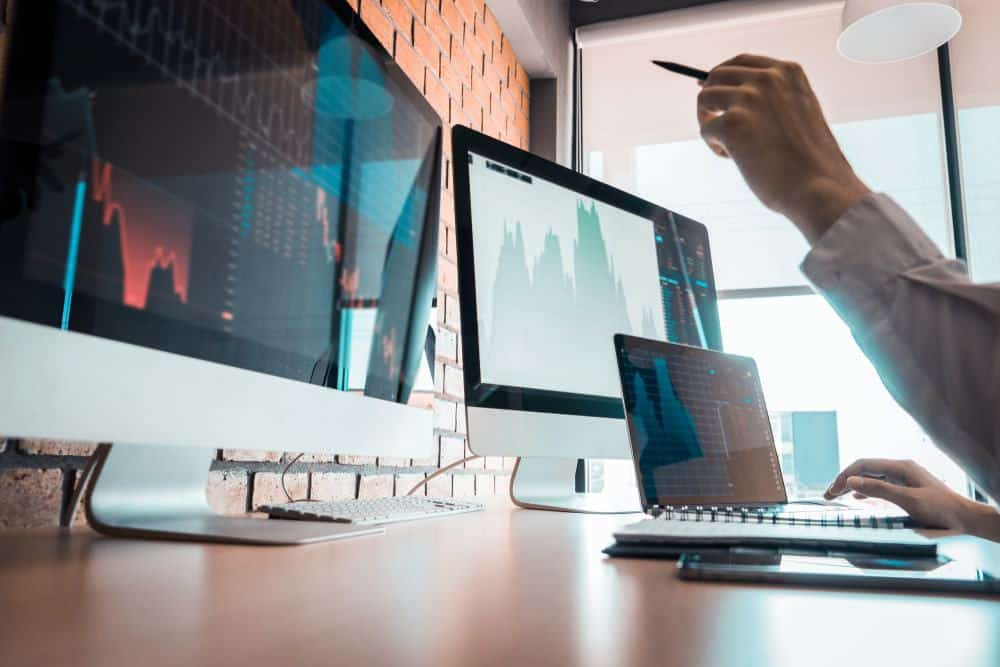 A man is working at a desk with two monitors.