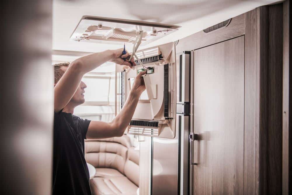 In a partnership with the Indiana Westville Correctional Center, a man is skillfully installing a light in an RV at RVTI.