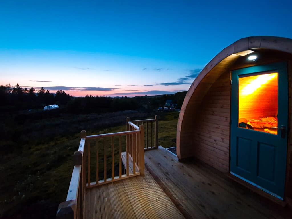A wooden cabin sitting on a deck at dusk.