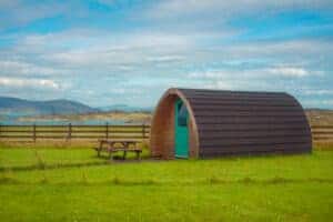 A proposed small cabin in a grassy field with a picnic table for glamping pods.