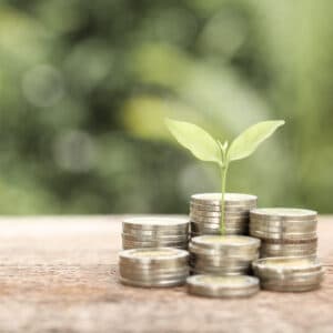 A stack of coins with a plant growing out of them, symbolizing the funding support provided by Wainwright for outdoor recreation projects.