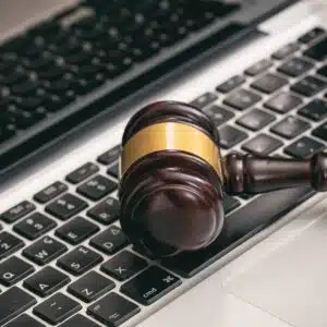 A wooden gavel sits on top of a laptop, symbolizing the Auction Donations or the March Conference organized by CCRVC.