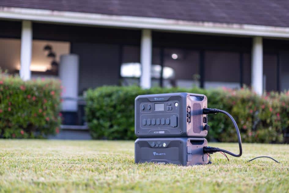 A BLUETTI portable generator sits on the grass in front of a house, ready to kick off the Spring Sale.