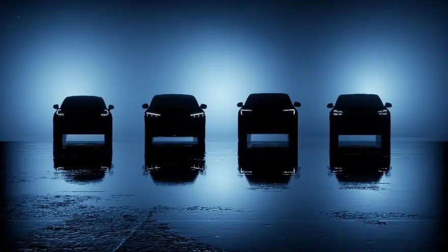 Four bold, all-electric Ford SUVs are lined up in a dark room.