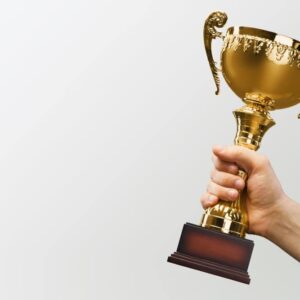 A man holding up a gold trophy in British Columbia, showcasing the excellence of tourism and hospitality in the region.