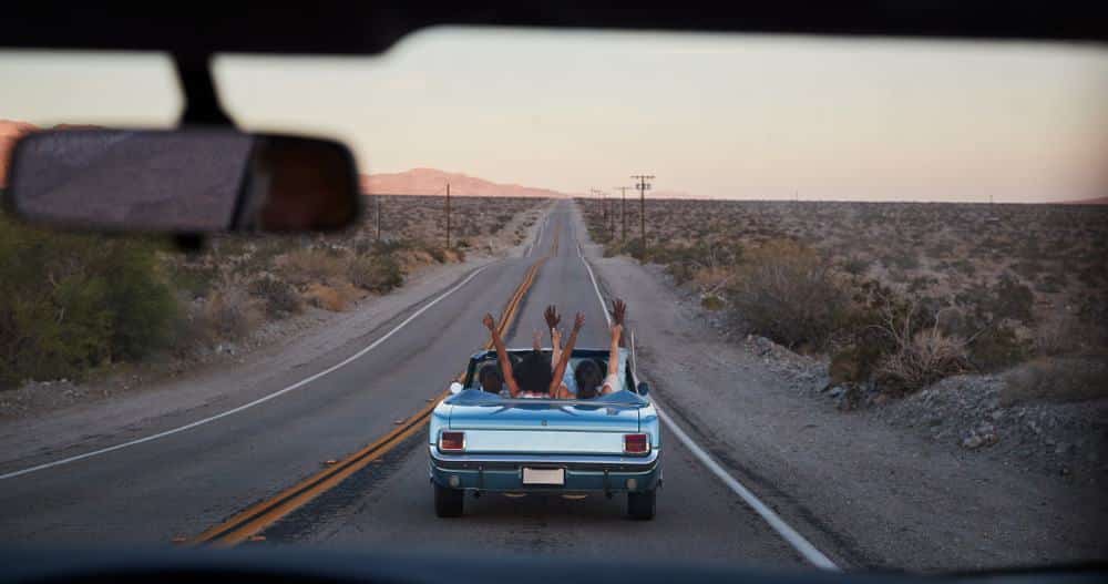 Two Americans in a car on a road trip through the desert.