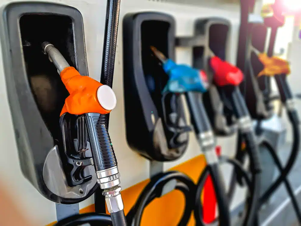 A line of gas pumps with different colored nozzles serving American drivers.