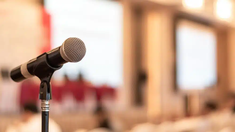 A microphone in front of an audience discussing the controversial Appeals case for a Glamping Development in Gallatin County.