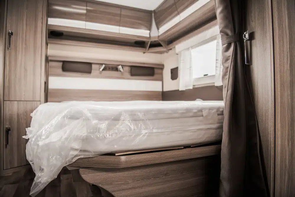 The interior of an industry-first motorhome with a bed, featuring Lippert biodegradable components.