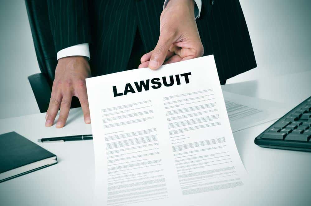 A businessman holding a paper with the word lawsuit on it at the Outer Banks.