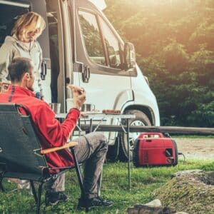 A group of people sitting around a campfire in front of an RV enjoying the scenic beauty and tranquility of Upstate South Carolina.
