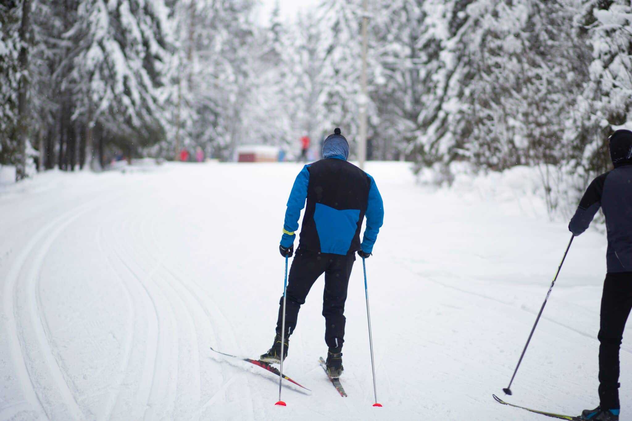 Two people cross country skiing on the trails near Westcove Campground in the snow.