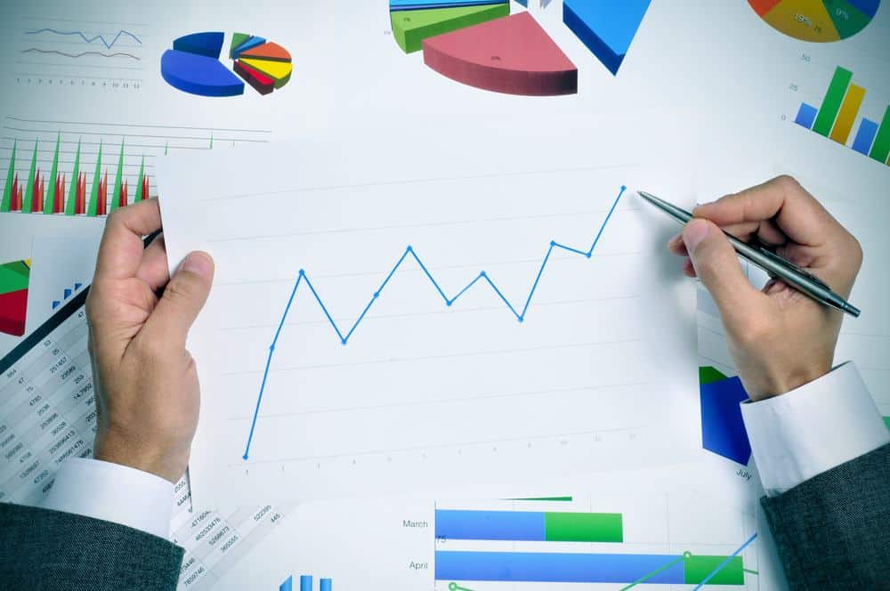 A person holding a pen and paper with financial graphs on it, displaying Q4 results for Horizon Global.