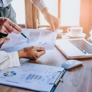 Two business people working on a spreadsheet at a desk, utilizing storage capabilities for data expansion.