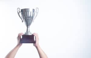 Person holding a silver trophy at the Australian Tourism Awards.